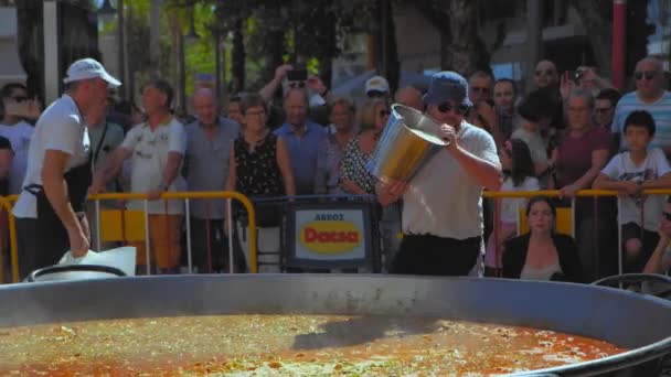 スペインのDenia 2019年7月 接近中だ 男は米を沸騰し パンで肉を炒めるために米から作られたバレンシアから伝統的なパエリアを調理します — ストック動画