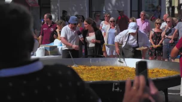 スペインのDenia 7月2019 ジャーナリストのクローズアップは 米から伝統的なバレンシアのパエリアを調理しました — ストック動画