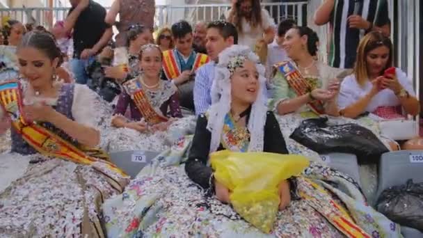 Fröhliche Mädchen Spielen Konfetti Sitzen Traditionellen Kostümen Auf Einer Straße — Stockvideo