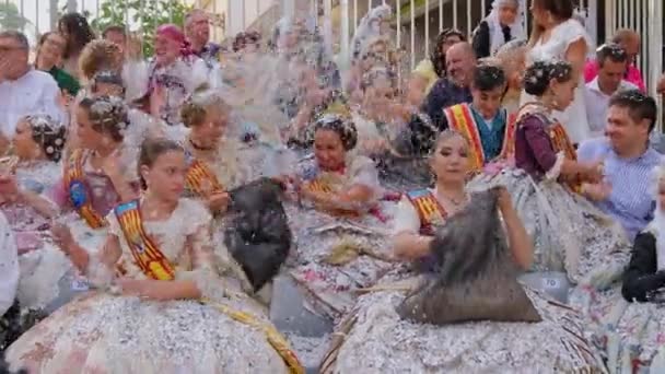 Fröhliche Mädchen Spielen Konfetti Sitzen Traditionellen Kostümen Auf Einer Straße — Stockvideo