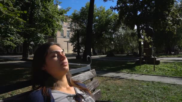 Jong meisje heeft een rust slaapt op een bankje in het park — Stockvideo