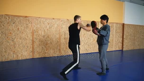 Två killar tränar mixed martial arts i hallen kämpar konst — Stockvideo