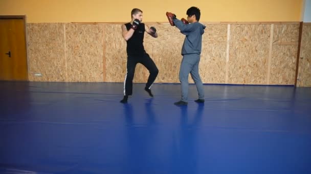 Dos tipos están entrenando artes marciales mixtas en la sala de artes de lucha — Vídeos de Stock