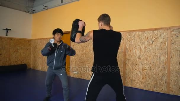 Dos tipos están entrenando artes marciales mixtas en la sala de artes de lucha — Vídeos de Stock