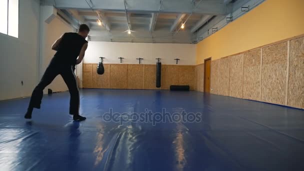 Młody mężczyzna trenerów boks cień w hali Mma — Wideo stockowe