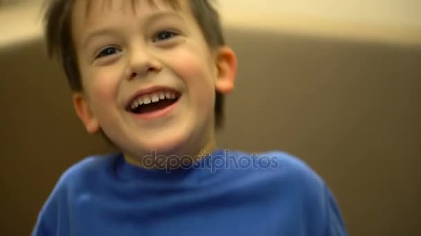 Мальчик веселится дома на диване — стоковое видео