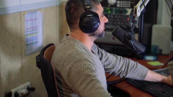Ραδιόφωνο παρουσιαστή στο μικρόφωνο σε μια ζωντανή ραδιοφωνική εκπομπή στούντιο — Αρχείο Βίντεο