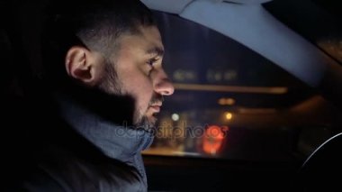 Adam akşam sokakta bir araba direksiyonuna