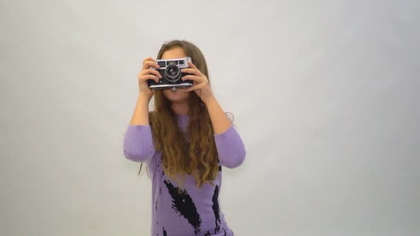 Petite fille avec un appareil photo vintage ona fond blanc — Video