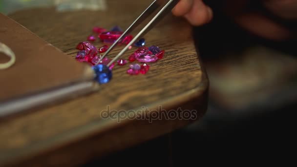 Piedras preciosas sobre una mesa de madera y selección de la muestra necesaria para un anillo de plata . — Vídeo de stock