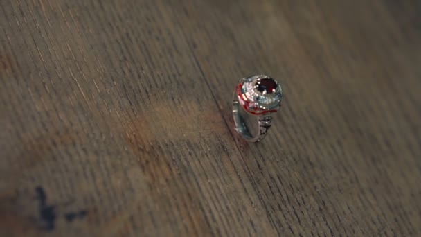 Silberring mit Email und Edelsteinen auf einer Holzoberfläche — Stockvideo