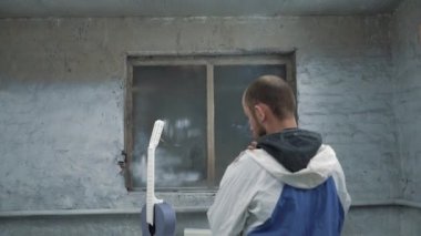 Ressam gitar ve sigara görünüyor. Ve boya kabini ışığı söner