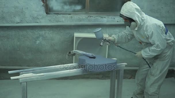 Man in a protective coverall applies a layer of gray on the guitar with a tools — Stock Video