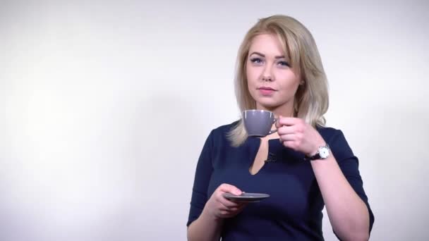 TV-Moderatorin trinkt Kaffee aus grauer Tasse — Stockvideo