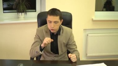 Patron onun boğazını temizledi ve bir konuşma yapmak için önce bir deri sandalyede oturan gömlek yakasını doğruldu