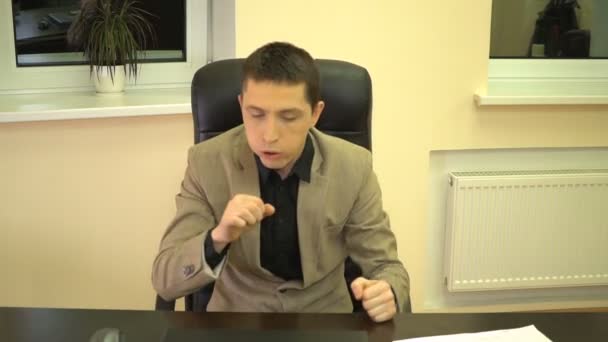 Boss rensat sin strupe och rätade hans skjortkrage som sitter i en skinnfåtölj innan för att göra ett tal — Stockvideo