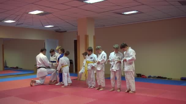 KIEV, UCRANIA - 6 de febrero de 2017: Sensei ayuda a ponerse el kimono antes del inicio del entrenamiento de Taekwondo — Vídeo de stock