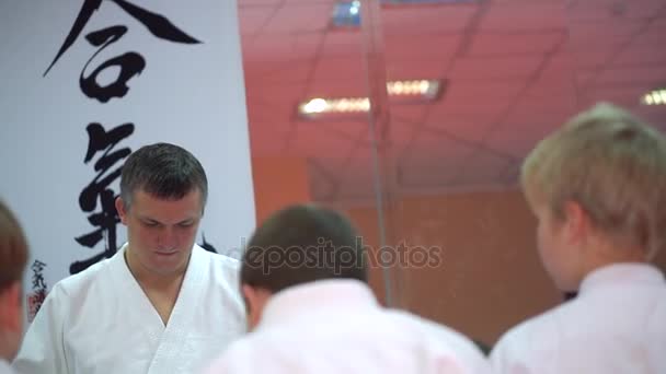 KIEV, UKRAINE - 6 de fevereiro de 2017: Instrutor de Taekwondo faz anotações e grupo de crianças em um quimono olha para ele — Vídeo de Stock