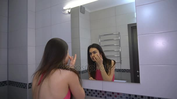 Girl takes care of the skin and puts a cream foundation on the face — Stock Video