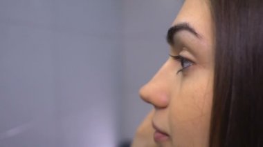 Esmer makyaj yakın çekim profilinde kaşları yapıyor