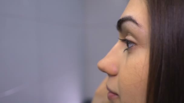 Брюнетка делает брови макияж крупным планом — стоковое видео