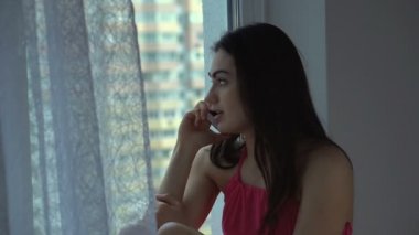 Diş telleri kızla telefonda konuşma bitmiş ve pencereden görünüyor