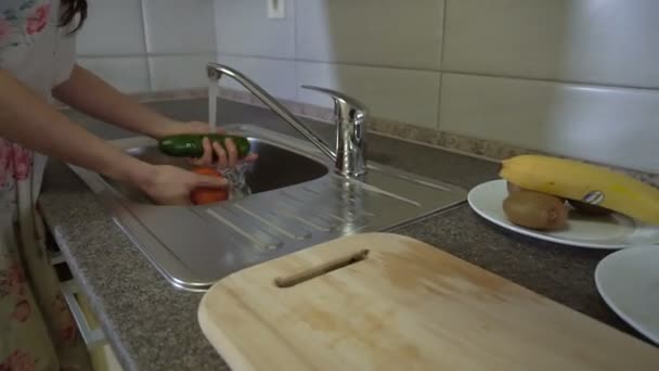 Meisje wast groenten vóór begin van snijden en koken — Stockvideo