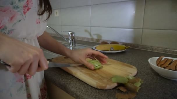 Morena chica hace rebanadas de fruta — Vídeo de stock