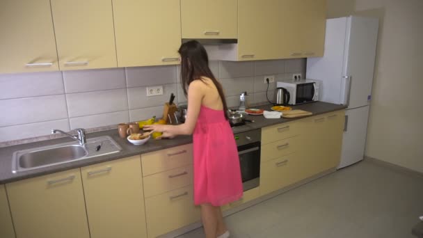Girl hurries and runs from the kitchen with sandwich to work — Stock Video