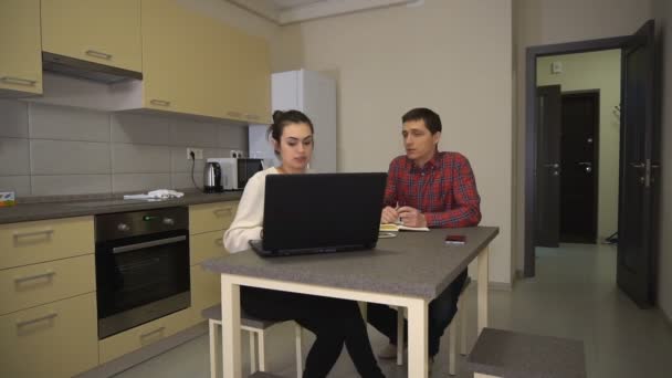 Девушка и парень обсуждают семейные дела, сидя перед ноутбуком — стоковое видео