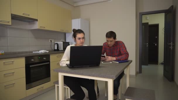 Работа на дому мужчина с телефоном и женщина с ноутбуком — стоковое видео