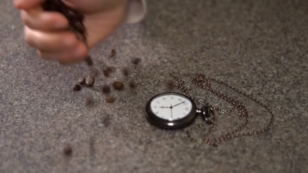 Kaffeebohnen sind neben der Uhr verstreut — Stockvideo