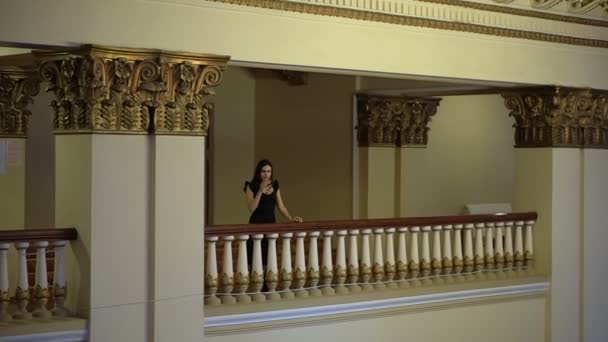 Femme regarde en bas du balcon et boit du vin — Video