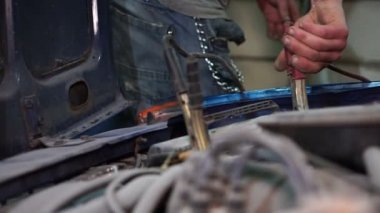 Çocuk makinist araba aküsü denetler