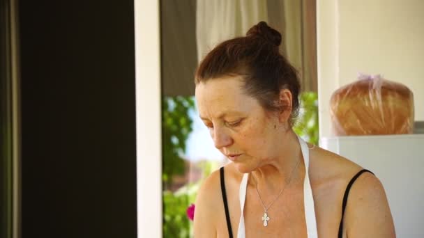 Yaşlı kadın mutfak arka plan üzerinde konuşuyor — Stok video