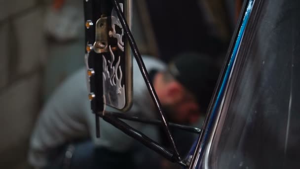 Rückspiegel und ein Mann repariert Auto im Hintergrund — Stockvideo