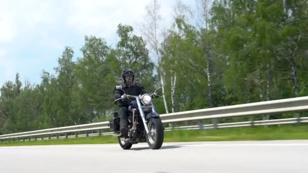 Мотоциклист на дороге и деревья на обочине дороги — стоковое видео