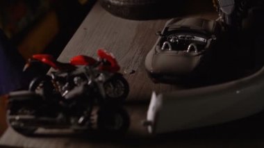 Model arabalar ve motosikletler someones el koyar motosiklet üstünde belgili tanımlık masa ve dümen