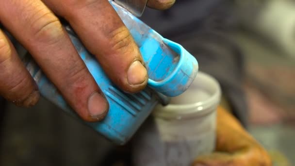 Man häller färg i en plastbehållare — Stockvideo