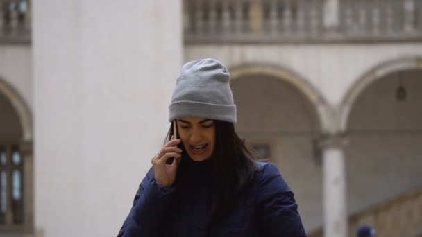Brunett tjej pratar på den telefon står på torget — Stockvideo