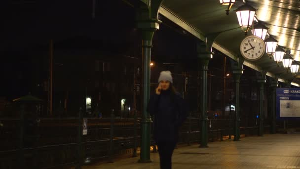 Hablando por teléfono mientras esperas en la estación de tren — Vídeo de stock