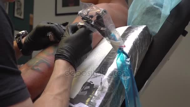 Tatuagem artista faz uma tatuagem em um ombro clientes — Vídeo de Stock