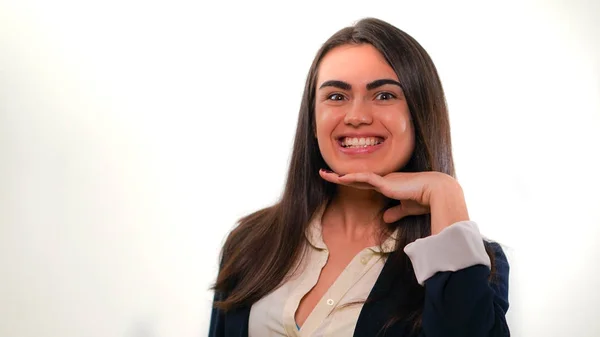 Elini çenesinin için iş koyarak genç gülümseyen kadın portresi uygun beyaz arka plan üzerinde
