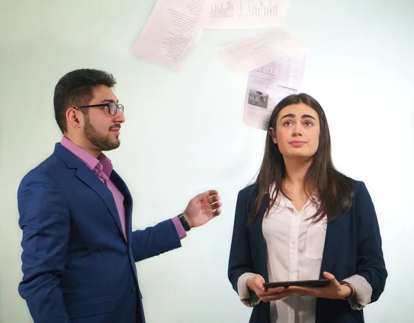Patron kağıtları tablet elinde tutan gözlerini arar karışık olan bir kız ofis çalışanı atıyor