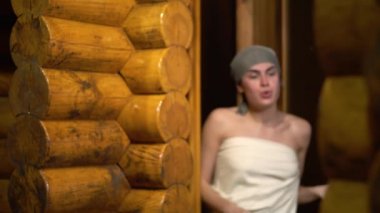 Esmer youn kız kafa bandı kapalı sauna alır dışarı onun baş ve gülümseyerek mutlu bir şekilde rahatlamış ile gelir