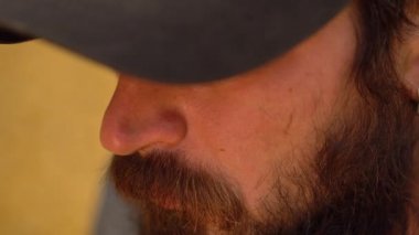 Portre yakın çekim bir sakallı beyaz adamın gözlerini gizleme bir siyah şapkalı