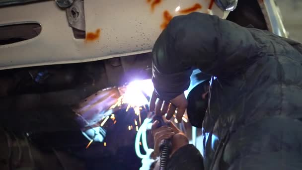 Homme soudeur répare la carrosserie réparation étincelles de métal chauffé — Video