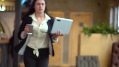 Genç esmer kız ile bir dizüstü bilgisayar ve bir kahve eller acele bir masaya oturmak için çalışmak için posta ve almak başlangıç kontrol