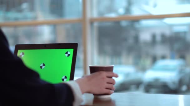 Fille avec un écran vert sur un ordinateur portable de travail et de boire du café — Video