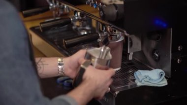 Barista kahve hazırlama süt kırbaçlanan bir dövme adamla